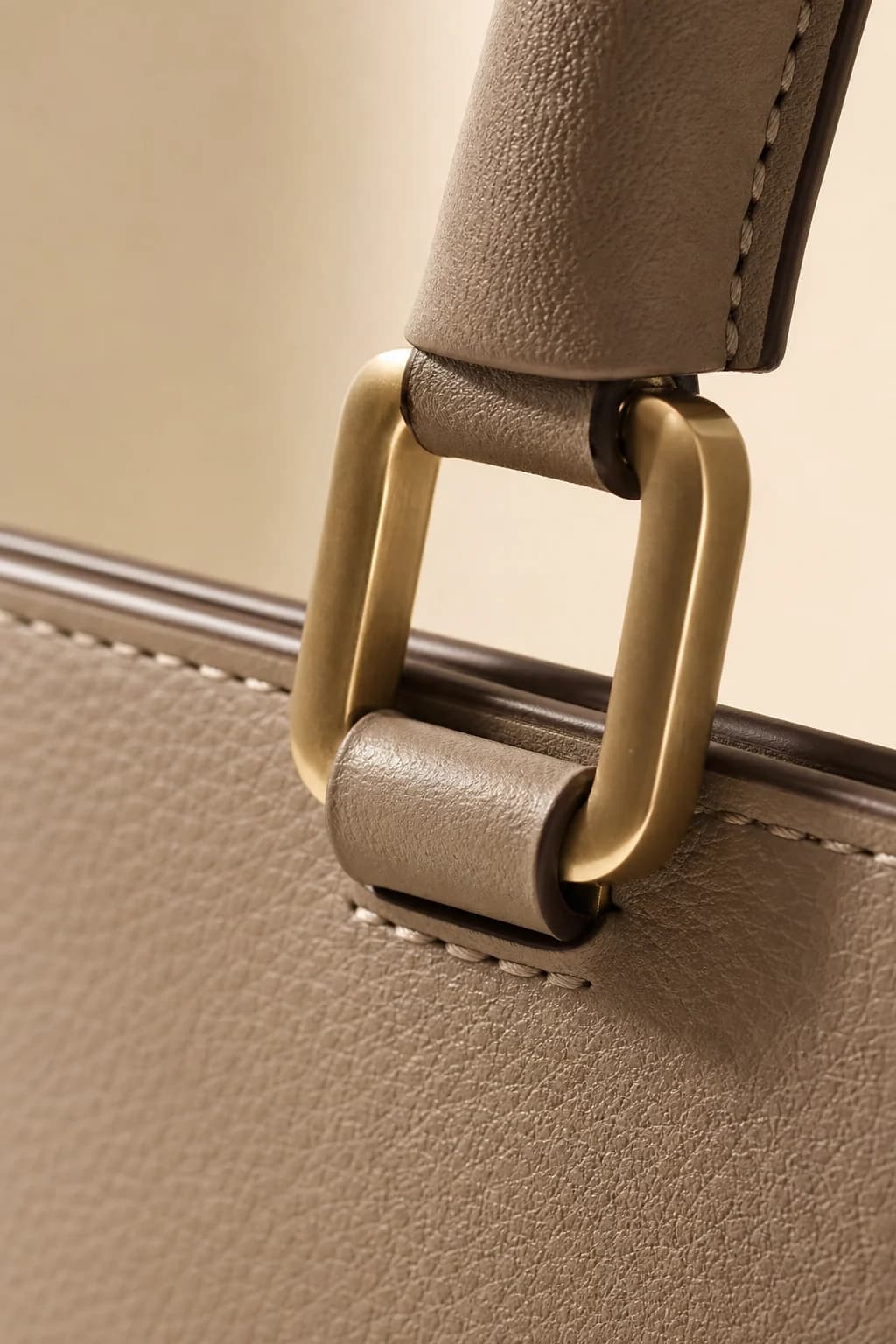 Close-up of precise handbag stitching and champagne-toned hardware