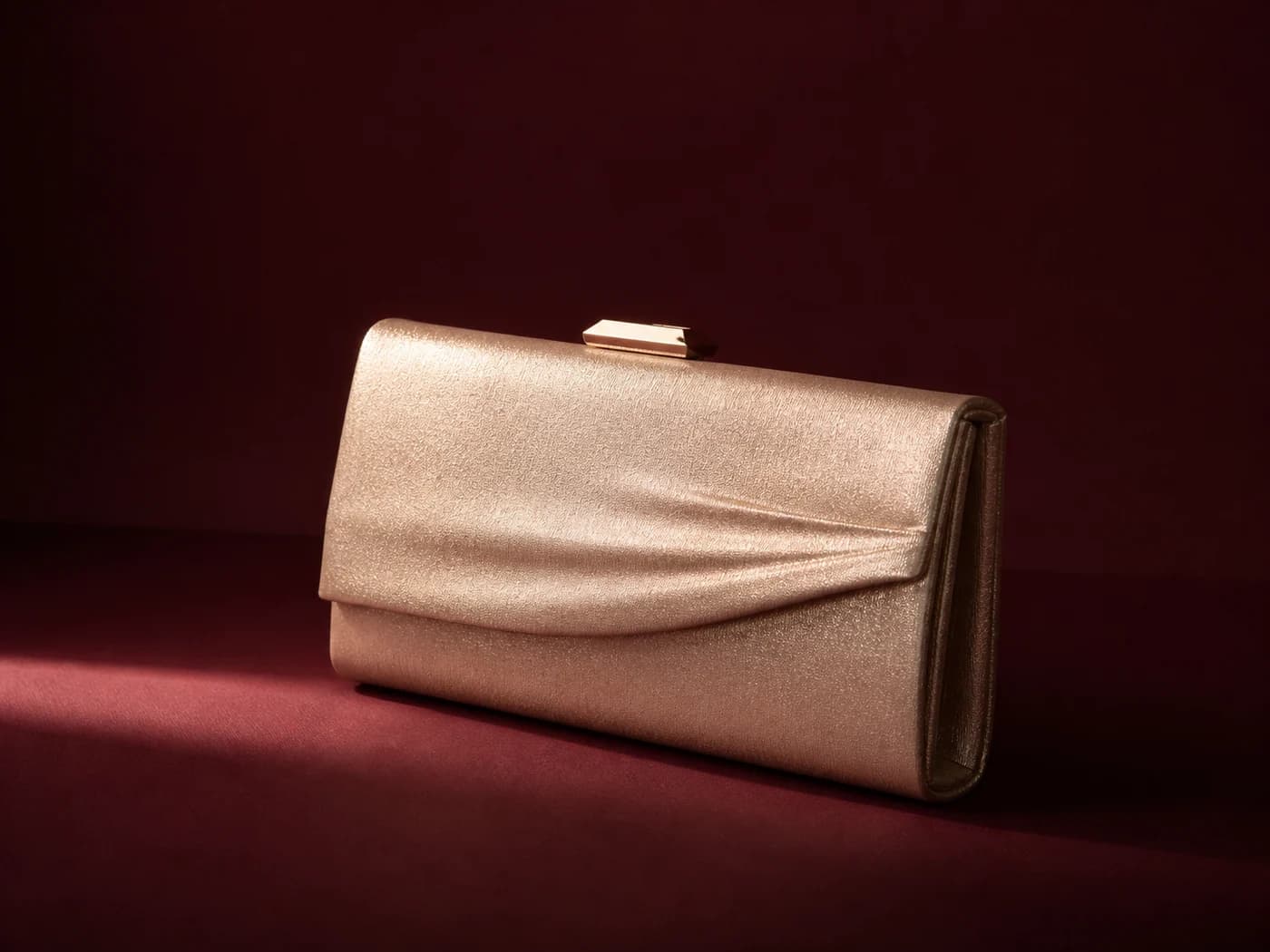 Champagne metallic evening clutch on an oxblood set